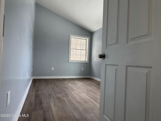 spare room with vaulted ceiling and wood-type flooring