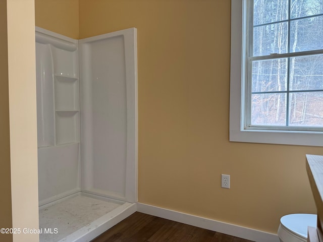 bathroom featuring hardwood / wood-style floors, plenty of natural light, and a shower