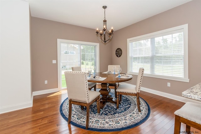 dining space with hardwood / wood-style flooring and a notable chandelier