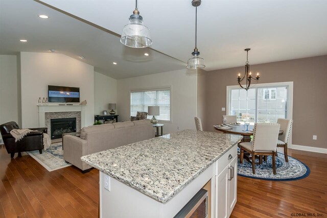 kitchen with white cabinetry, a wealth of natural light, light stone countertops, and pendant lighting