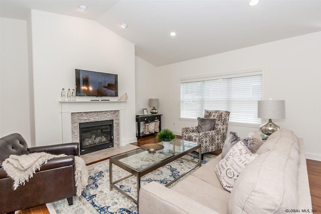 living room featuring lofted ceiling, hardwood / wood-style floors, and a fireplace