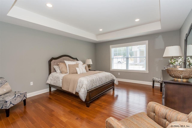 bedroom featuring dark hardwood / wood-style floors and a raised ceiling
