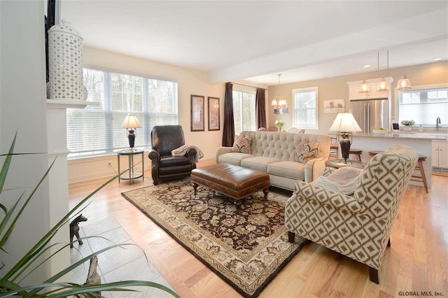 living room with a notable chandelier and light wood-type flooring