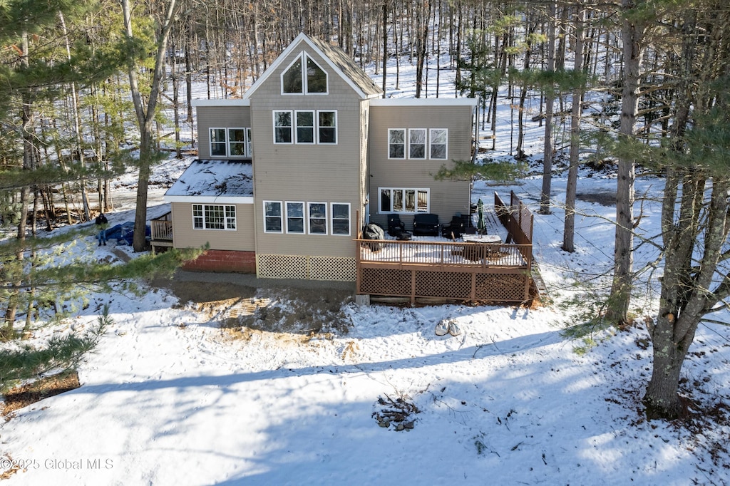 snow covered property with a deck