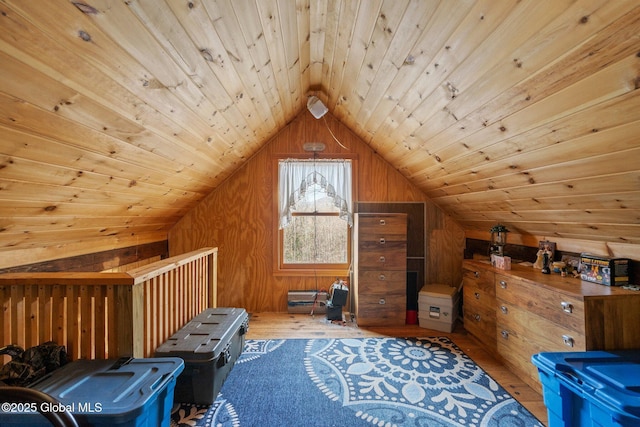 additional living space with hardwood / wood-style flooring, wood walls, vaulted ceiling, and wooden ceiling