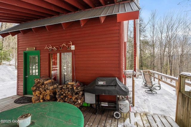 snow covered deck with an outbuilding and a grill