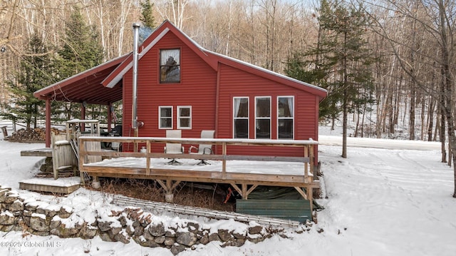 snow covered house with a deck