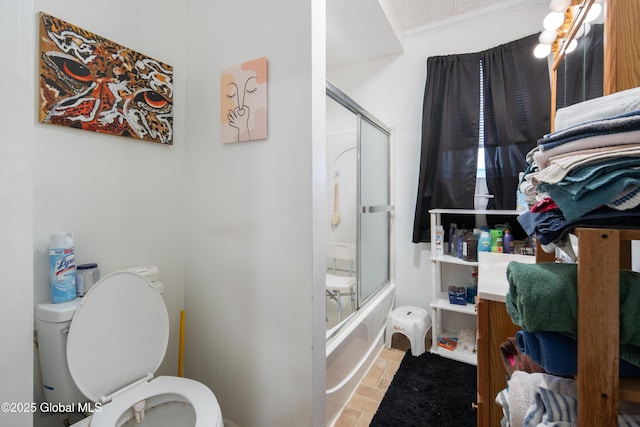 bathroom with combined bath / shower with glass door and toilet