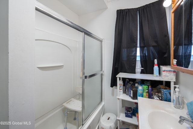 bathroom featuring sink and combined bath / shower with glass door