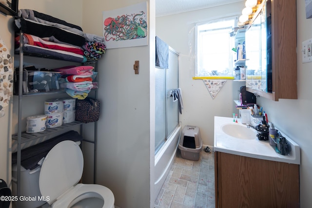 full bathroom featuring enclosed tub / shower combo, vanity, and toilet