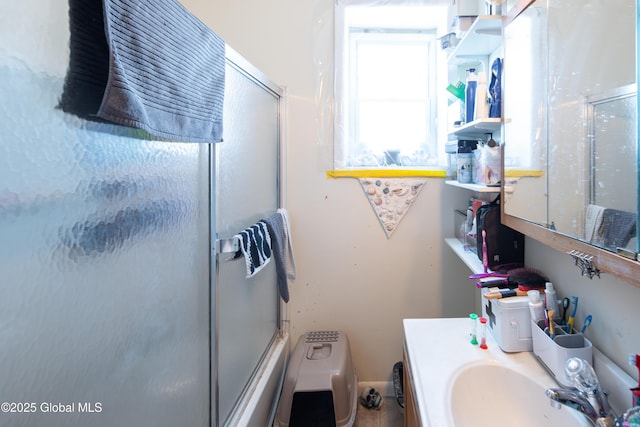 bathroom featuring enclosed tub / shower combo and vanity