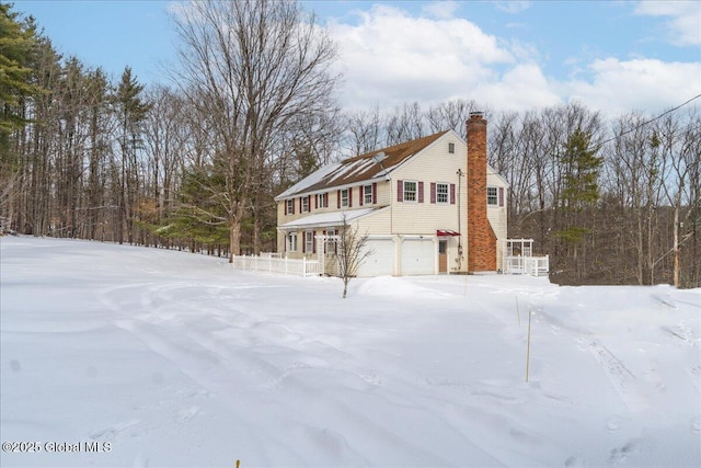 snow covered property featuring a garage