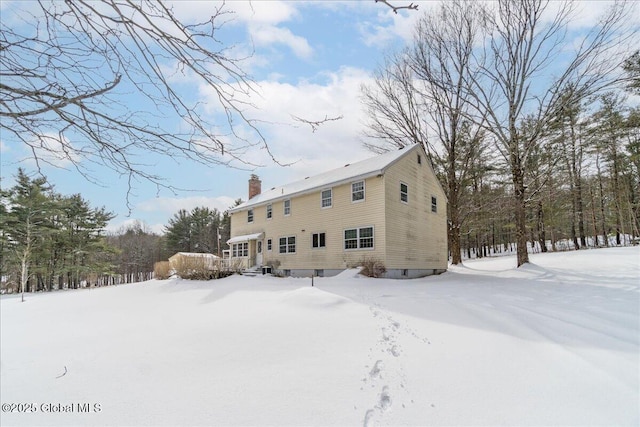 view of snow covered rear of property