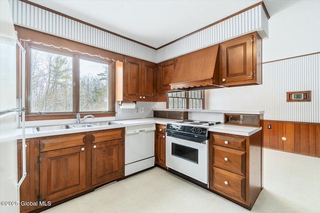 kitchen with premium range hood, white appliances, and sink