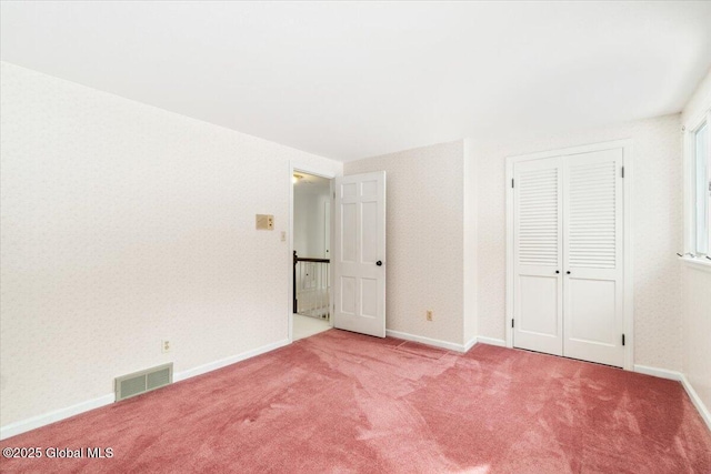 unfurnished bedroom featuring carpet floors and a closet