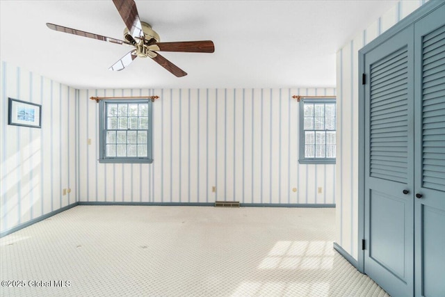 carpeted spare room featuring ceiling fan