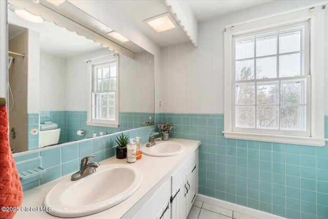 bathroom featuring vanity, tile patterned floors, tile walls, and toilet