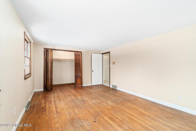 unfurnished bedroom with a closet and light hardwood / wood-style flooring