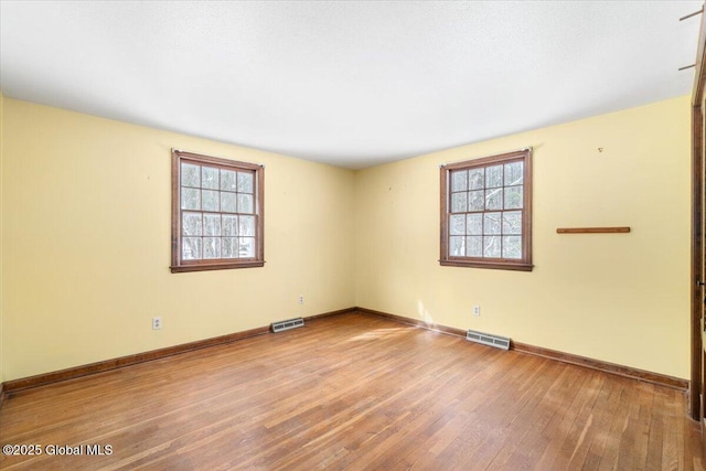 spare room featuring plenty of natural light and light hardwood / wood-style flooring