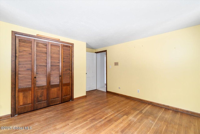 unfurnished bedroom with hardwood / wood-style floors and a closet