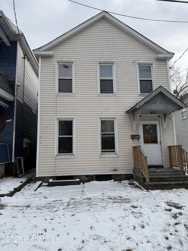 view of snow covered rear of property