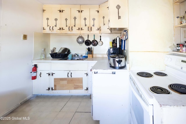 kitchen featuring white electric stove, sink, and white cabinets