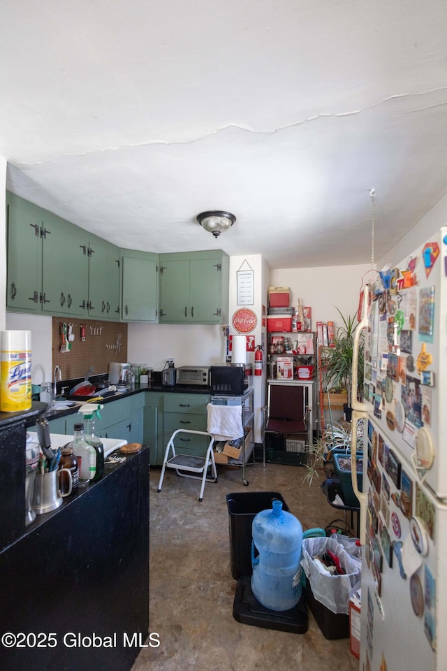 kitchen with green cabinetry and white fridge