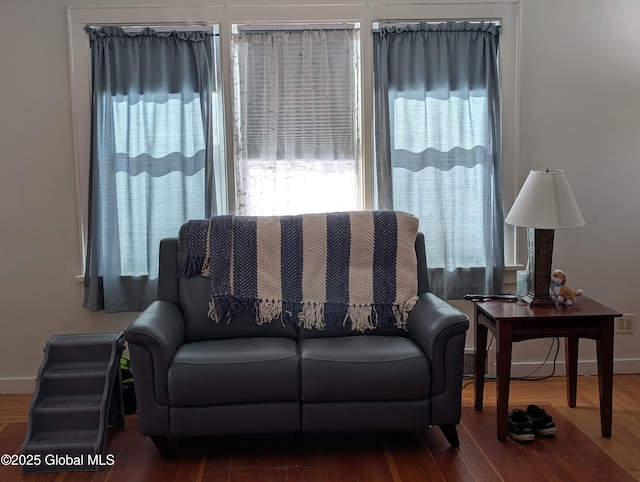 living area featuring baseboards and wood finished floors