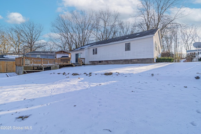 snow covered rear of property featuring a wooden deck