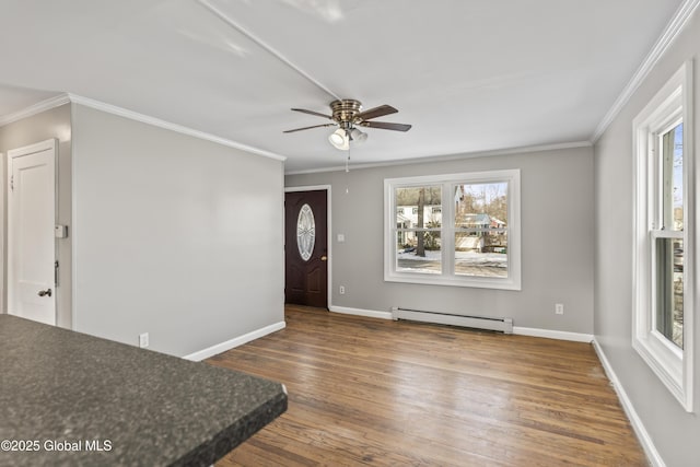 entryway featuring a healthy amount of sunlight, a baseboard heating unit, and ornamental molding