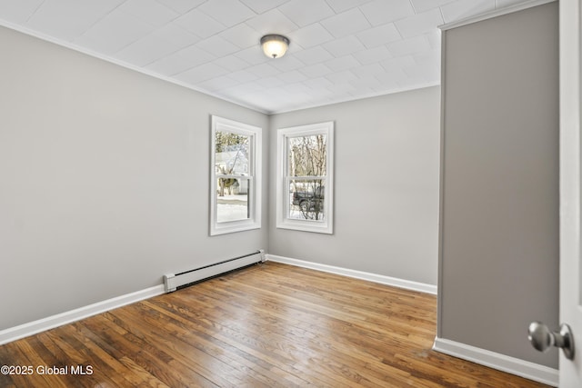 empty room with crown molding, a baseboard radiator, and wood-type flooring