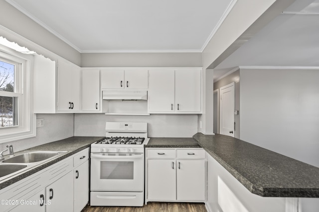 kitchen with white range with gas stovetop, ornamental molding, dark hardwood / wood-style flooring, kitchen peninsula, and white cabinets