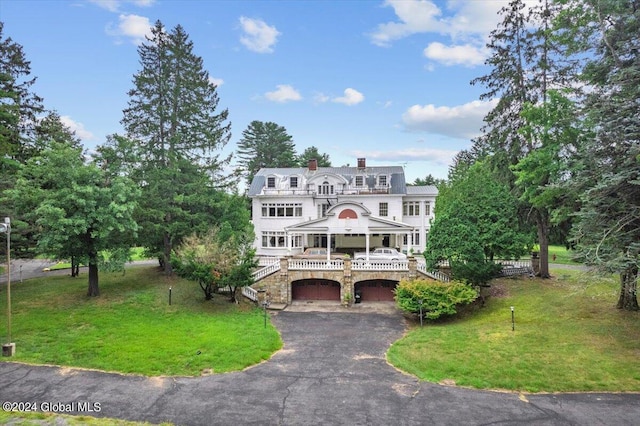 view of front of home with a deck and a front lawn