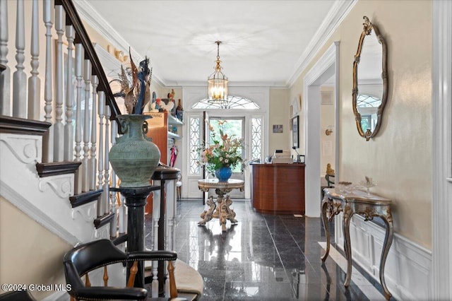 entrance foyer featuring a notable chandelier and crown molding