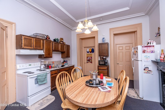 kitchen with pendant lighting, carpet floors, ornamental molding, white appliances, and an inviting chandelier