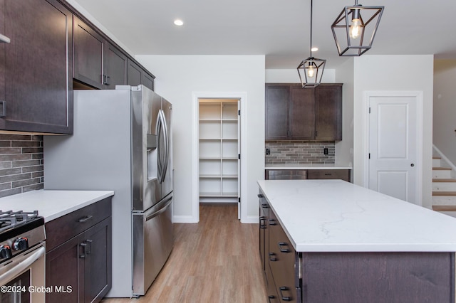 kitchen featuring dark brown cabinetry, a kitchen island, and hanging light fixtures