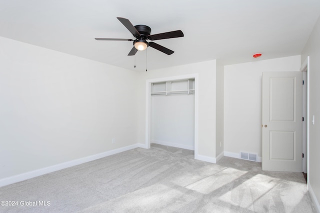 unfurnished bedroom featuring light carpet, ceiling fan, and a closet