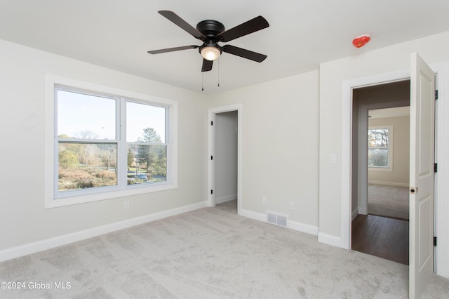 unfurnished bedroom with light colored carpet and ceiling fan