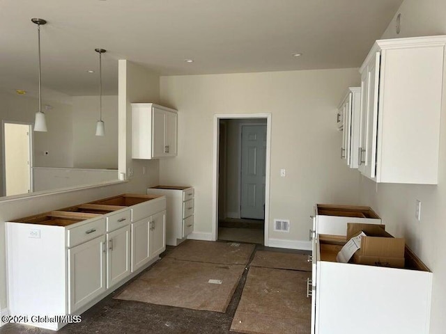 kitchen featuring hanging light fixtures, white cabinetry, and dark tile patterned flooring