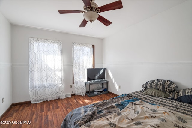 bedroom featuring baseboards, visible vents, wood finished floors, and ceiling fan