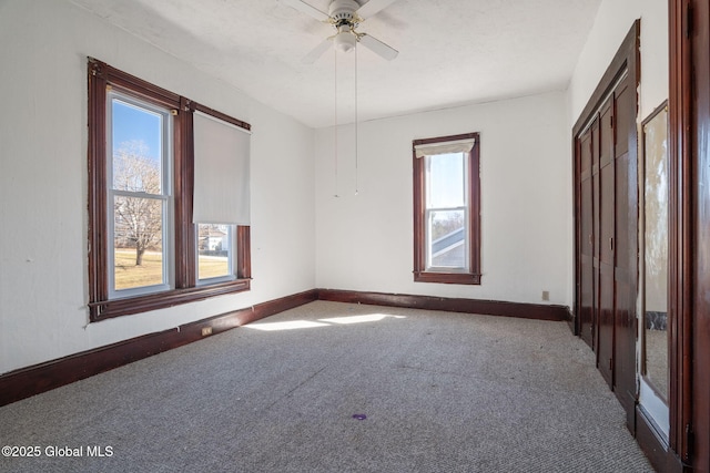 unfurnished bedroom featuring baseboards, carpet, and a ceiling fan