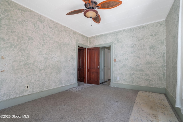 unfurnished room with ornamental molding, baseboards, wallpapered walls, carpet floors, and ceiling fan