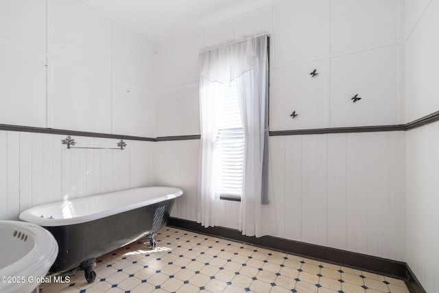 full bath featuring tile patterned floors and a freestanding bath
