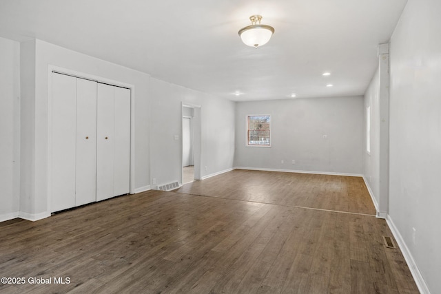 unfurnished bedroom with dark hardwood / wood-style floors and a closet