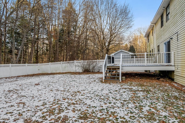 snowy yard with a wooden deck