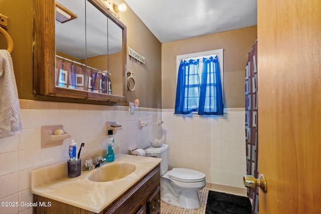 bathroom featuring tile walls, vanity, tile patterned floors, and toilet