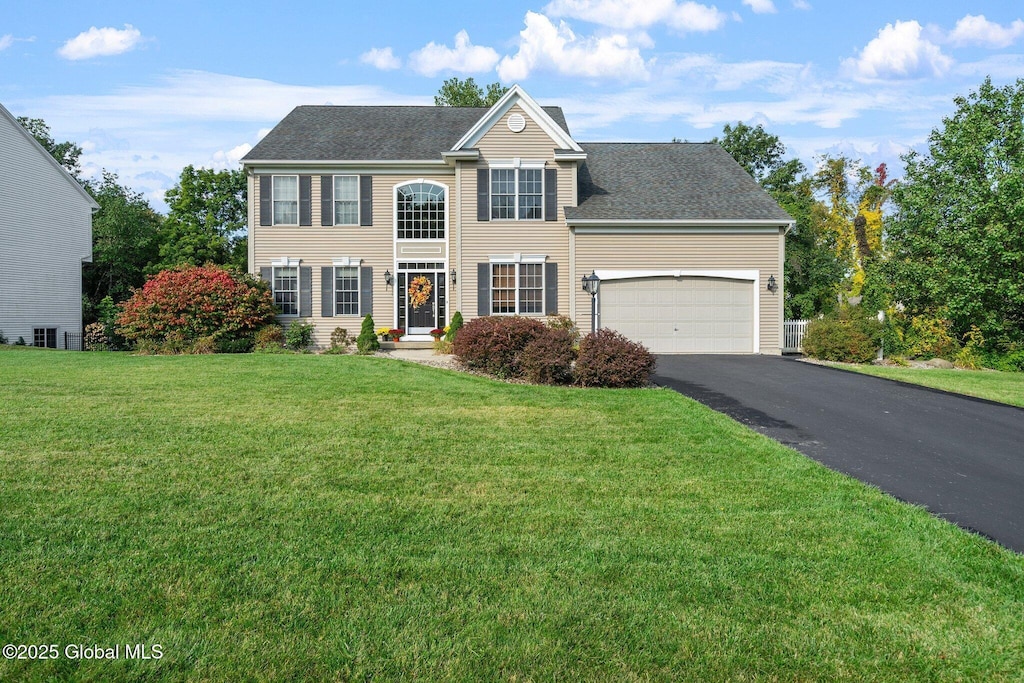 view of front of house with a garage and a front lawn