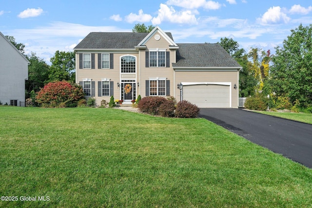 view of front of house with a garage and a front lawn