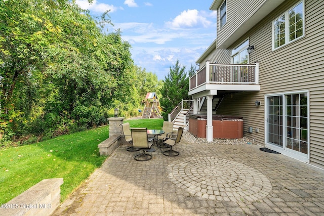 view of patio with a hot tub and a playground