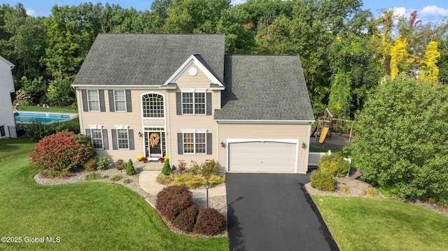 view of front of house featuring a garage and a front lawn